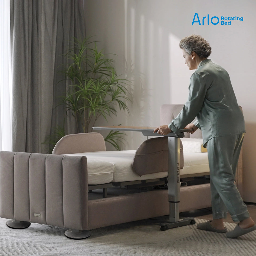 Arlo sit-to-stand hospital bed with integrated standing frame and bedside tray table